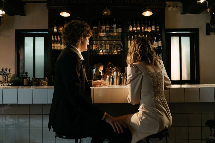 Man en vrouw aan de bar, tijdend de eerste date